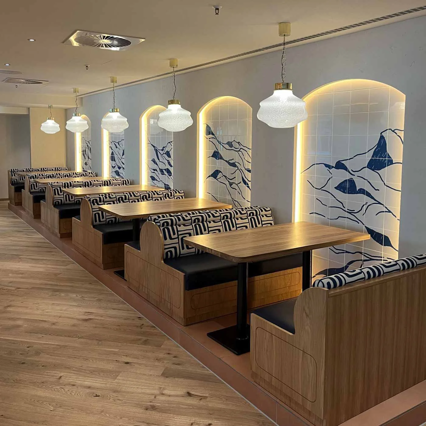 Restaurant-Wandgestaltung mit bedruckten Fotofliesen in blauem Bergmotiv – individuelle Dekoration von 7color