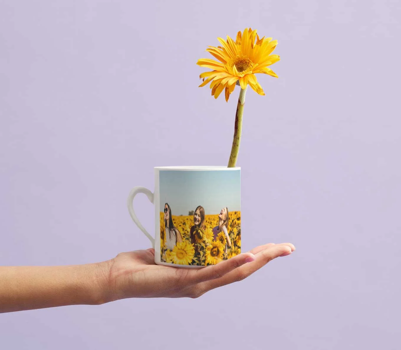 Hand hält eine bedruckte Fototasse mit Blumenmotiv als persönliches Geschenk