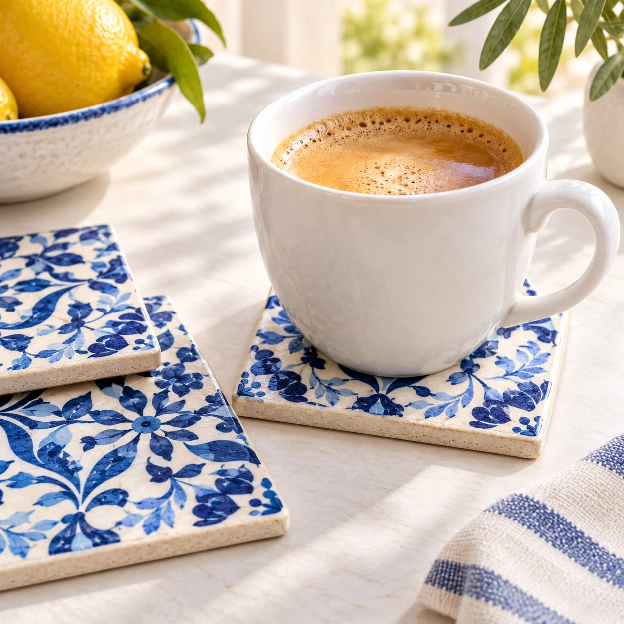 Drei Keramik-Untersetzer mit blau-weißem Ornament, auf einem davon eine Tasse Kaffee