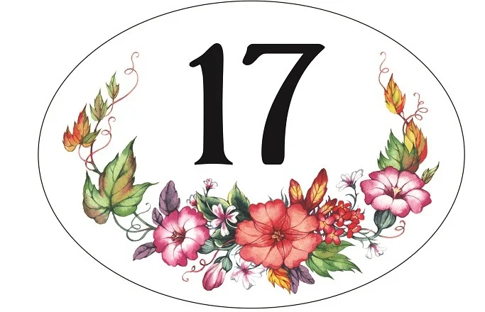 Ovales Hausnummernschild aus Porzellan mit der Nummer 17 und einem Blumenkranz
