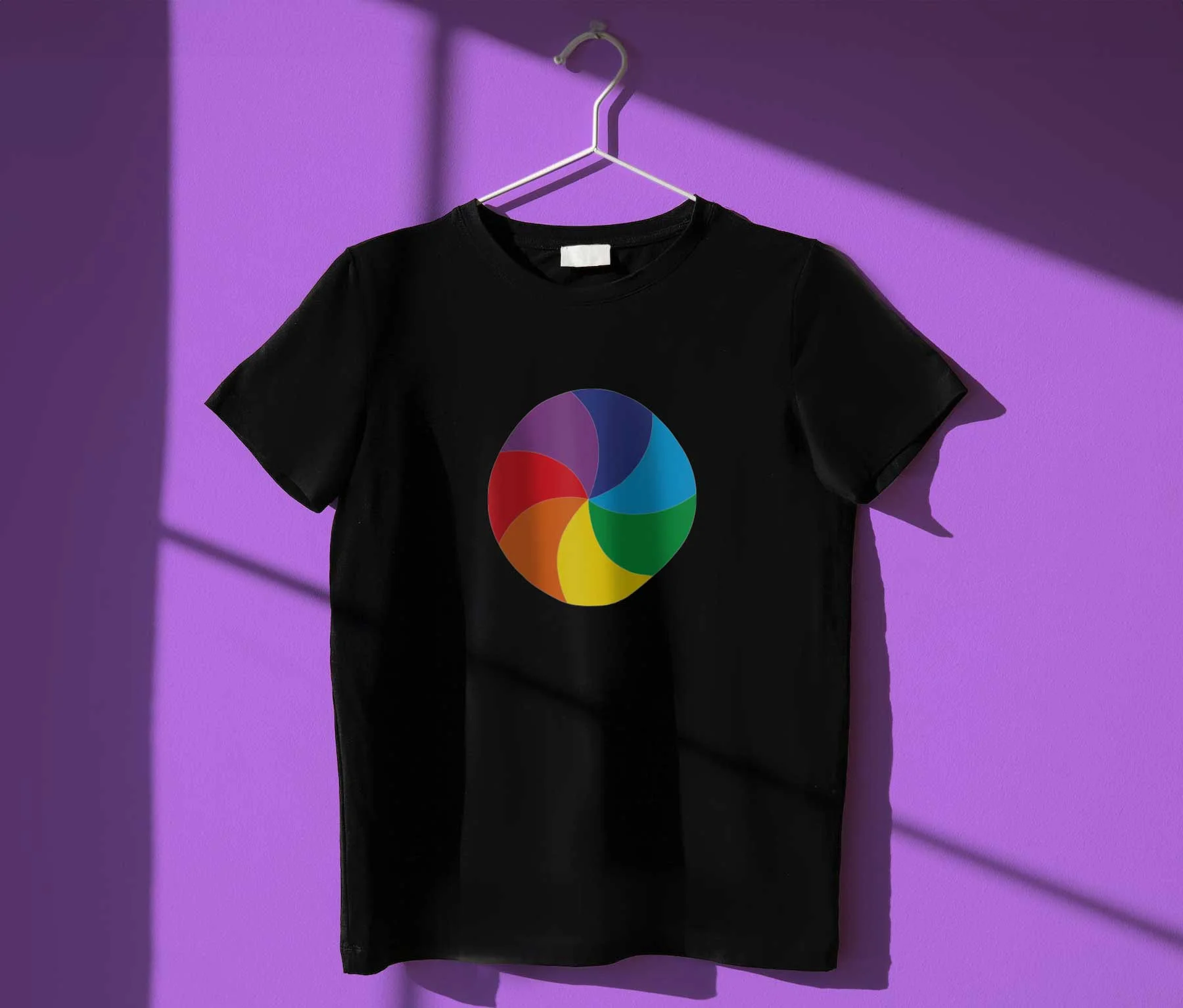 Schwarzes T-Shirt an einem Kleiderbügel mit buntem Farbrad-Logo vor violetter Wand